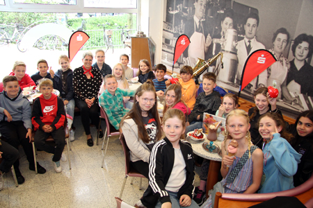 Sparkassenmitarbeiterin Monica Pogacic (Mitte) umringt von erfolgreichen Nachwuchsredakteurinnen und -redakteuren. Zur Siegerehrung beim 42. Schulzeitungswettbewerb gab’s Eis nach Wunsch und für jede Redaktionskasse 300 Euro von der Sparkasse am Niederrhein.