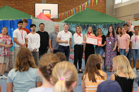 Melanie Peschik und Lena Kempken bei der symbolischen Schecküberreichung in der Turnhalle Asberg. Die Sparkasse am Niederrhein unterstützt die Tummelferien mit 1.000 Euro. (Foto: pst)